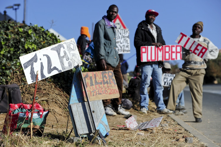 Unemployed painters, plumbers and tilers wait outside Builder's Warehouse in Johannesburg, South Africa, for job opportunities on June 6, 2012.