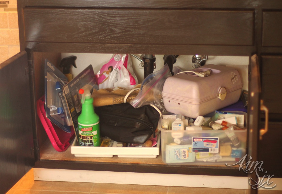 Messy under sink cabinet before