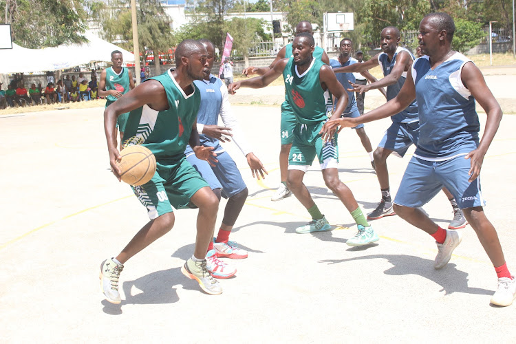 Wesley Asubwa of Vihiga county is blocked by Kisumu players during the men's basketball final