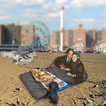 DREAMSCAPE: Going ahead with the "wedding," John wants to snuggle with Phyllis inside the kind of quilt they slept in under the Coney Island boardwalk. A clam bake is in progress (rear), and Phyllis is wearing a wreath of flowers and her wedding band. DREAMSCAPE: Going ahead with the "wedding," John wants to snuggle with Phyllis inside the kind of quilt they slept in under the Coney Island boardwalk. A clam bake is in progress (rear), and Phyllis is wearing a wreath of flowers and her wedding band.