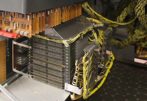 The 8,000 character core memory in the IBM 1406 Storage Unit consists of 16 layers (planes) of cores wired together. The matrix switches at the right (behind plastic) drive the control lines.