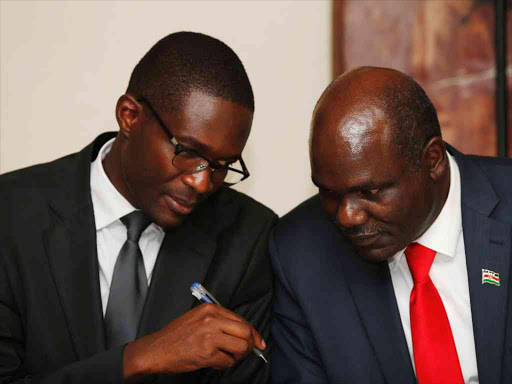 IEBC Chairman Wafula Chebukati (R) confers with the CEO Ezra Chiloba at the press conference in Nairobi where they announced the cancellation of the registration of voters in the diaspora who are outside Africa on February 7, 2017. Photo/Jack Owuor