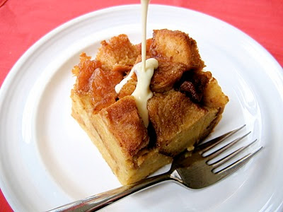 creme being poured onto slice of apple bread pudding 