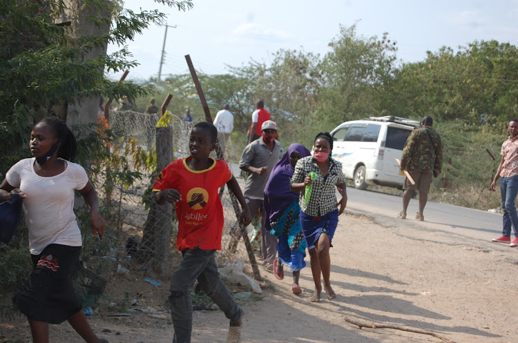 Residents of Garissa flee a protest following the killing by police of two people and wounding of another a woman on Saturday, July 25.