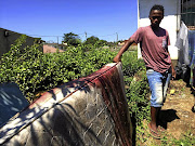 Khulekani Mzila with the mattress on which his brothers had been sleeping when they were shot.