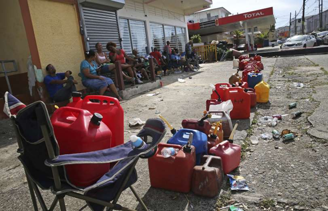 Family members collect belongings after hurricane force winds destroyed their house in Toa Baja, west of San Juan, Puerto Rico on 24 September 2017, following the passage of Hurricane Maria. Photo: RICARDO ARDUENGO / AFP / Getty Images