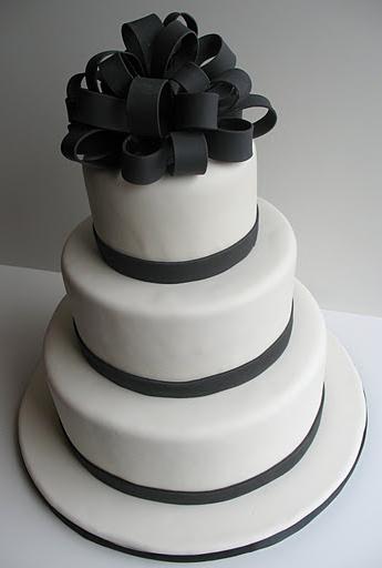 Black and white 3-tiered wedding cake with loopy bow cake topper. Cake was