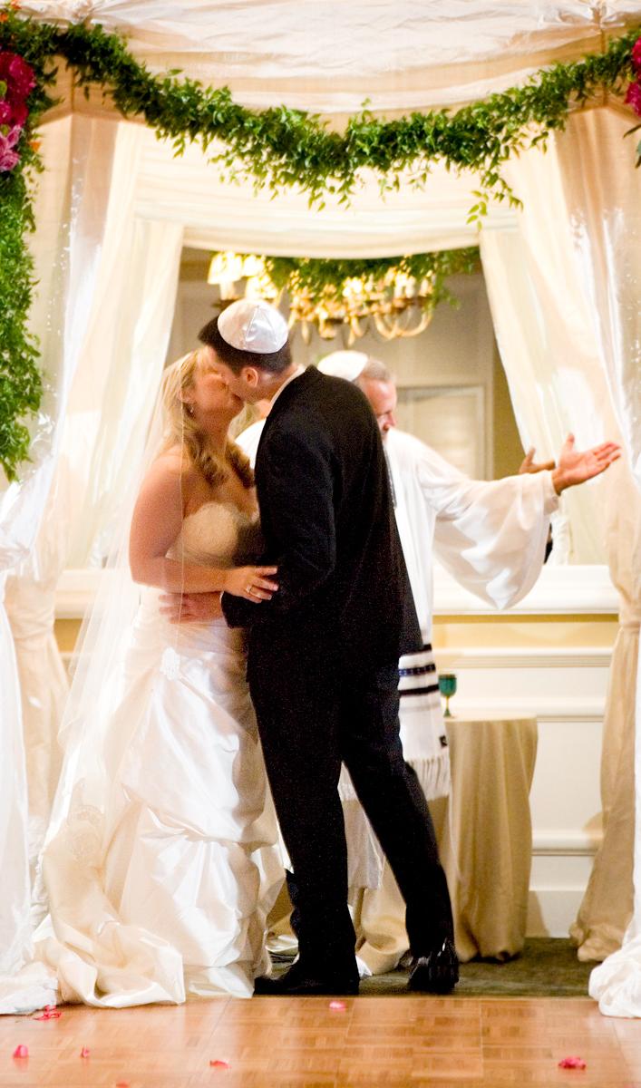 The bride and groom kiss near