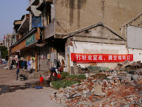 red banner reading "打好攻坚战,腾空地铁口" hung on a remaining building at Beizheng Street in Changsha