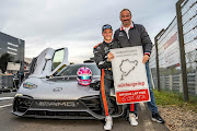 Maro Engel, seated, celebrates his achievement with Mercedes-AMG chair Philipp Schiemer.