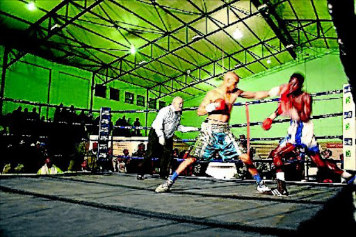 Ali Funeka, left, connects with a left to the head of Ghana's Justice Addy during their WBO Africa welterweight title fight at the Thobi Kula Indoor Sports Centre. Photo: BHONGO JACOB