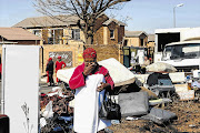 WHAT NOW? Dimakatso Koee, 65, with her seven-month-old granddaughter, Bophelo, on her back, was evicted from her daughter's rented townhouse in Honeydew, west of Johannesburg, yesterday. More than 50 families were forcibly removed from complexes in the area, allegedly for failing to pay rent since 2012