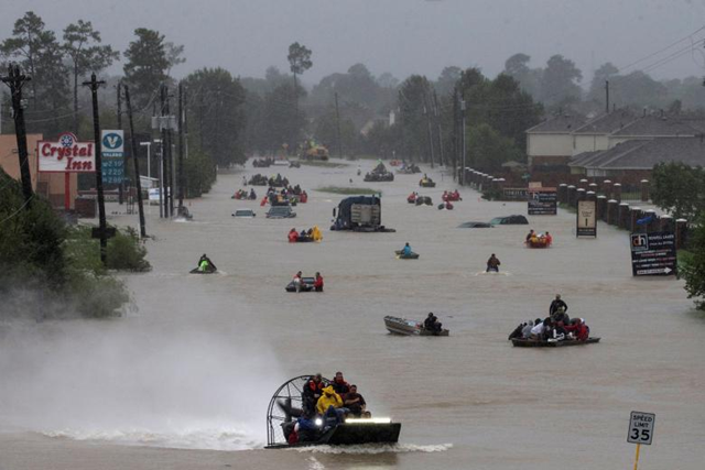 Residents use boats to evacuate flood waters along Tidwell Road in east Houston, 26 August 2017. Photo: Adrees Latif / REUTERS