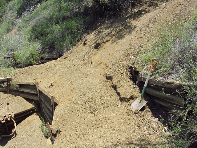 small, loose rocks falling down over the trail and a shovel to dig it out