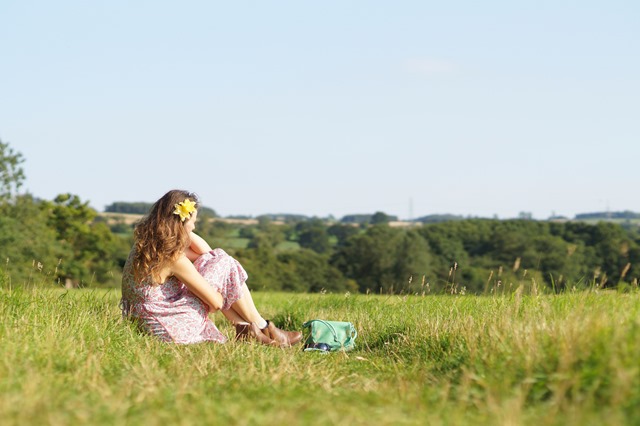 girl sitting in summer meadow