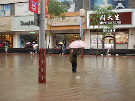 man standing in a flooded street in Taiyuan, China