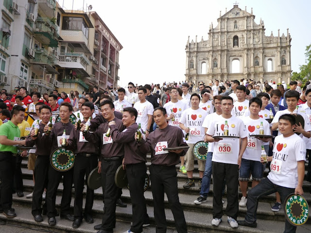 several young men proudly lifting their bottles of beer