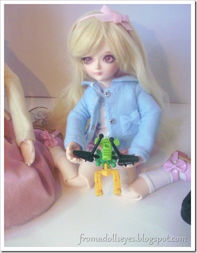 A yosd sized ball jointed doll holding a cool looking toy from a Kinder Joy pack.