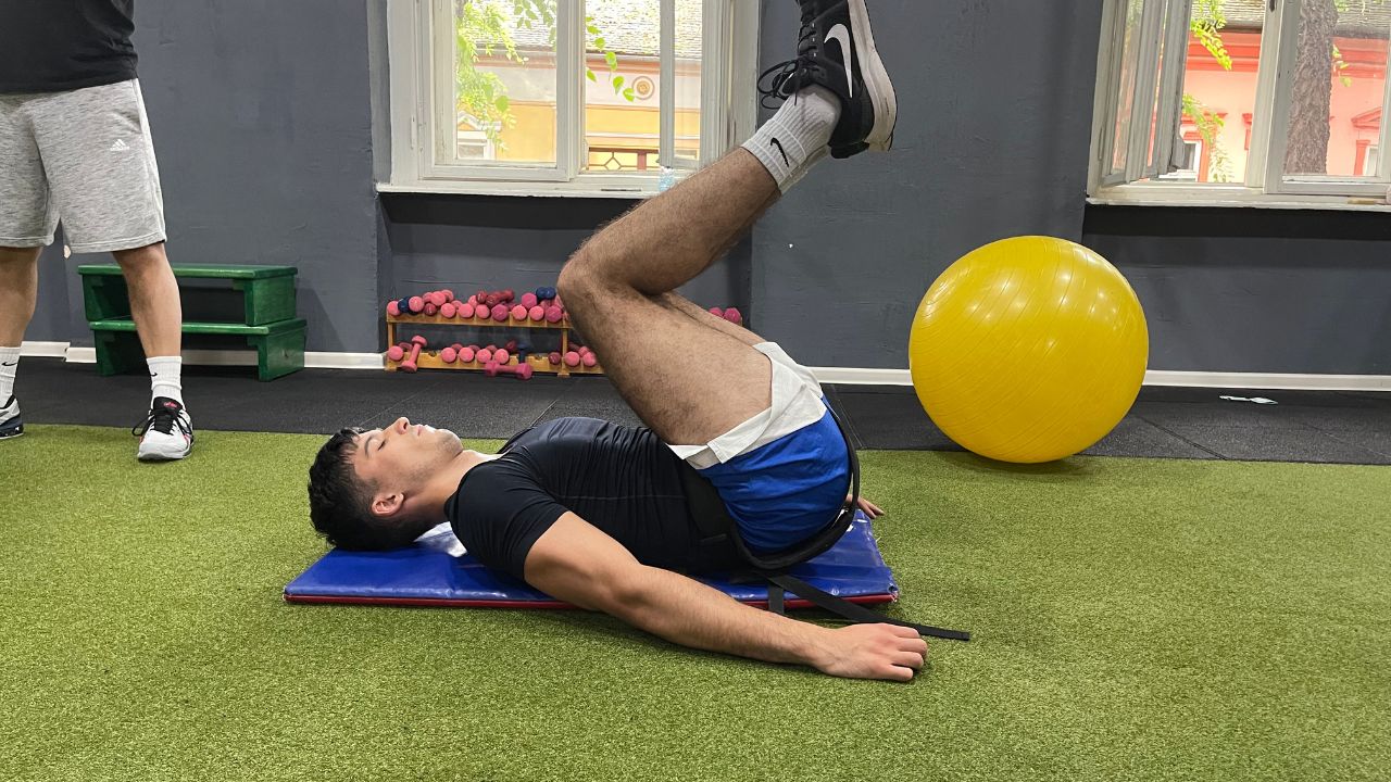 Vanja performs lower abdominal crunches for lower back pain in the commercial gym setup.