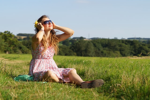 girl sitting in summer meadow