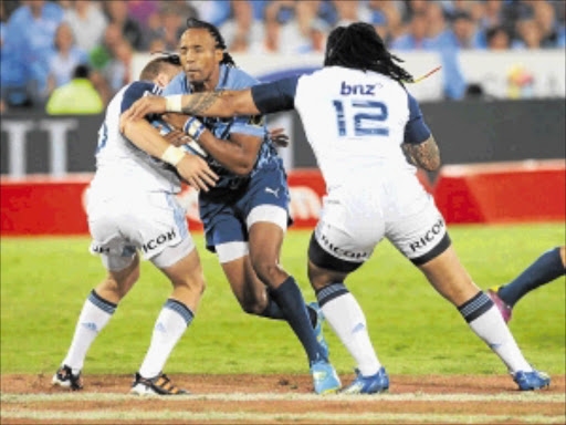 FIRST WIN: Blues scorer Gareth Anscombe and Ma'a Nonu tackle Akona Ndungane at Saturday's game against the Bulls. Photo: Gallo Images