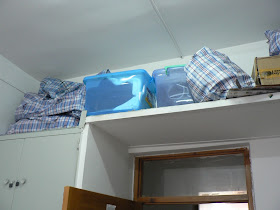 items stored on a shelve above a doorway in a dorm room at Dalian Maritime University in China