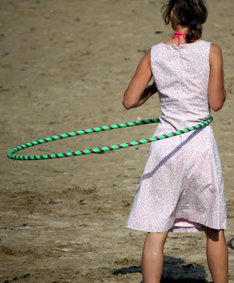 Vintage hula hooping on the beach in Cornwall in the UK