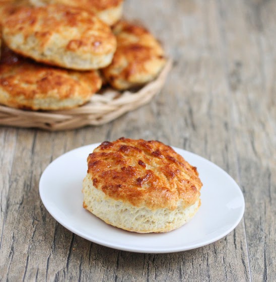 one buttermilk biscuit one a white plate.