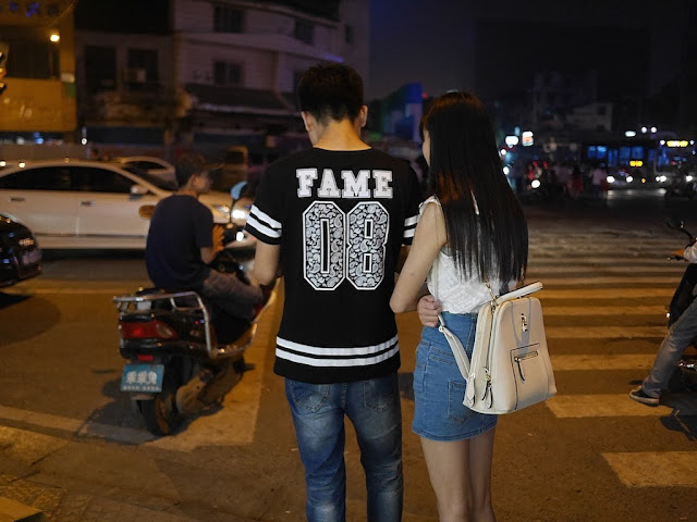 young man wearing shirt with "FAME 08" on the back with a young woman