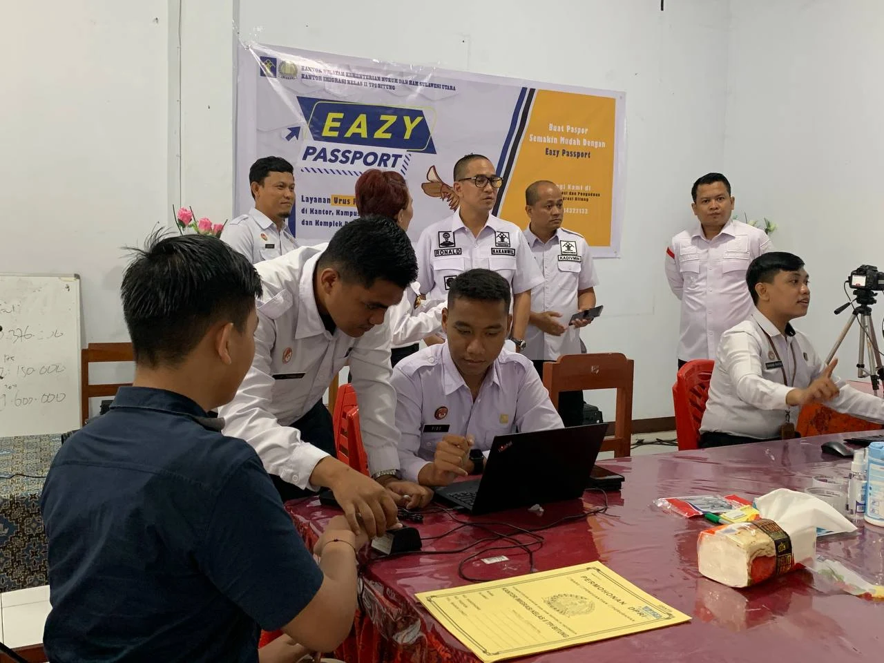 Kepala Kantor Wilayah Kementerian Hukum dan HAM Sulawesi Utara Ronald Lumbuun bersama Kepala Divisi Administrasi John Batara melakukan kunjungan pemantauan pelayanan Eazy Passport ke SMA Negeri 9 Manado. (Foto istimewa)