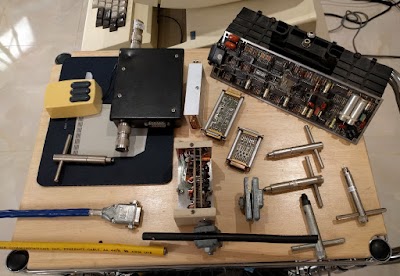 An assortment of vintage Ethernet transceivers, along with the tap tools used to drill holes in the Ethernet cable for the vampire tap connection.