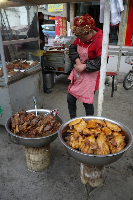 woman standing behind a pot of lamb and a pot of chicken in Yinchuan, Ningxia