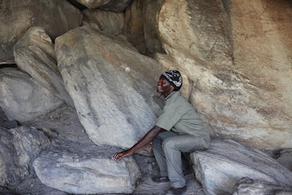 Our guide Phetolo demonstrating a reflex and coordination game - throw the rock in the air, move the small stones around, then catch the rock again.