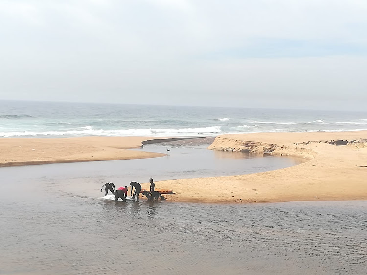 Police rescue personnel recover the body of a man from the Dakota Beach lagoon, south of Durban, on Tuesday December 18.