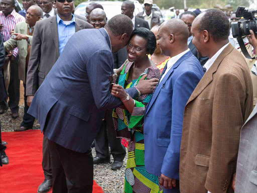 President Uhuru Kenyatta hugs Hon. Mattha Karua when he arrived for the launch of upgrade works of the Kutus-Kianyaga-Kiamutugu-Githure-Kibugu Road.Photo PSCU