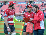 The Lions captain Warren Whiteley (L) congratulates Elton Jantjies on his man of the match award after a Super Rugby quarterfinal game against the Jaguares at Emirates Airlines Park Stadium, Johannesburg on July 21 2018.