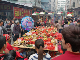 god figures facing a table of food during the Nian Li Festival (年例节) in Maoming, China