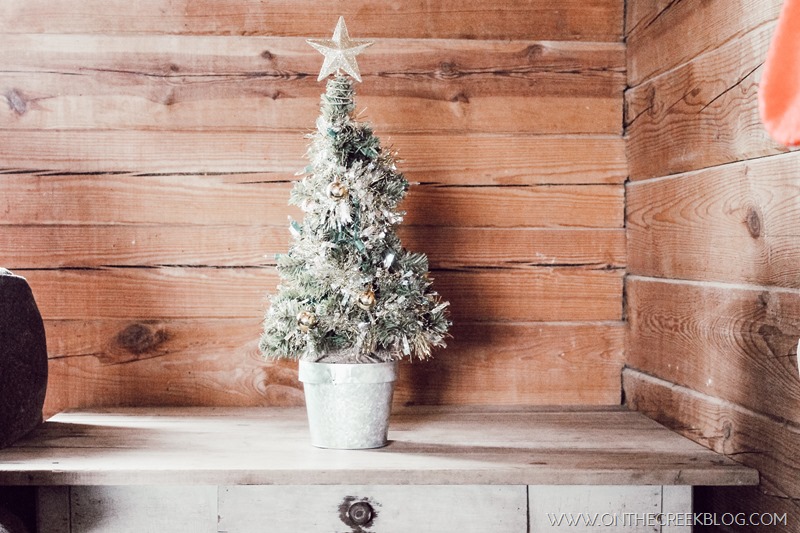 Decorating a small tree for Christmas using a tiny galvanized pot & Dollar Tree ornaments, tinsel & lights!