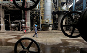 A worker walks past oil pipes at a refinery in Wuhan, China. Efforts to 'punish' Russia through sanctions are undermined by Russia's booming energy trade with China and India. File photo.