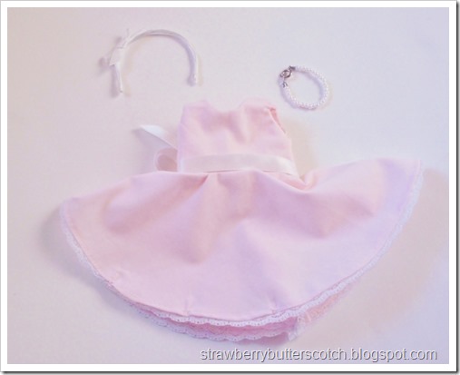 A pink vintage style dress set for a doll.