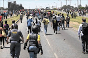 FREE FOR ALL: Zamdela  residents       
      loot the Zio liquor depot  
      
        during  an illegal 
      
       march to Sasolburg yesterday.
      
      
      
      
        PHOTOS: Antonio  Muchave
