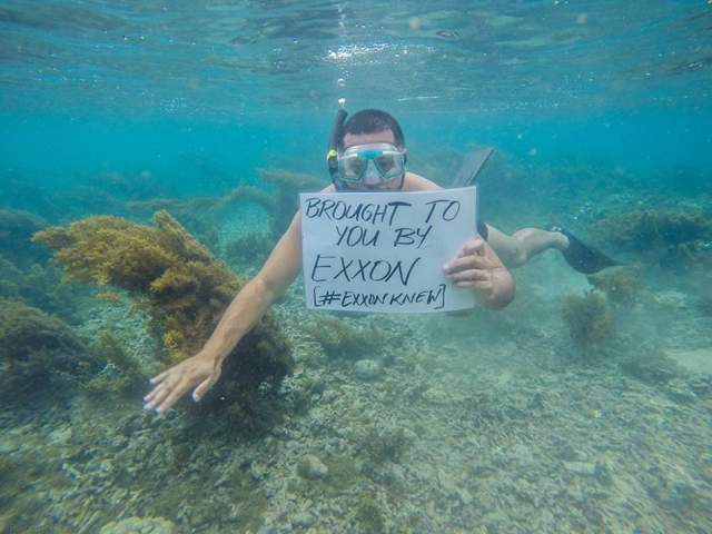 A 350.org activist snorkeling underwater holds a sign that reads, 'Brought to you by Exxon [#exxonknew]', in Palolo Deep, Apia, Samoa. In Palolo Deep in 2015, up to 10 percent of the reef died as a result of bleaching, while in some parts of Savai'i, 95 percent of the reef bleached. Photo: 350.org