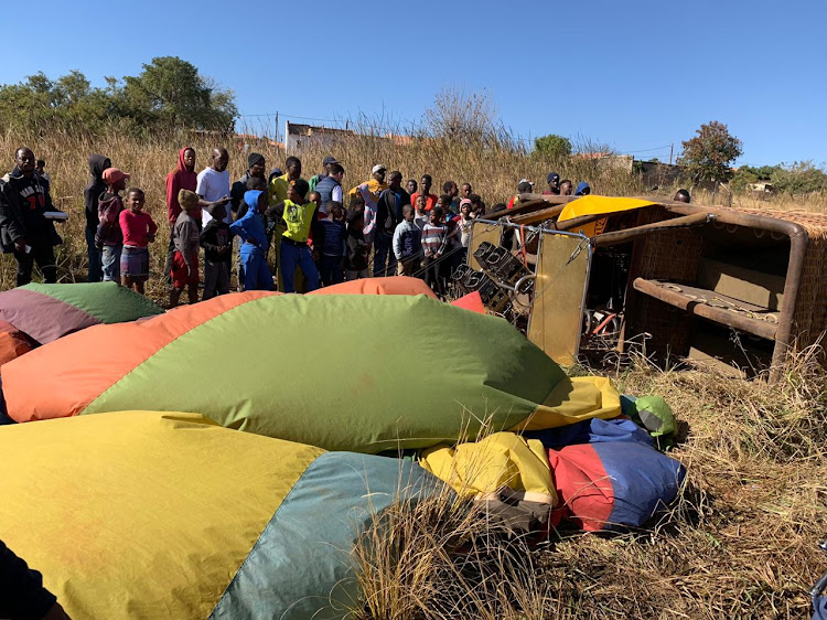 A crowd gathers around the basket of a downed hot air balloon in Soshanguve, Tshwane, on Saturday morning.