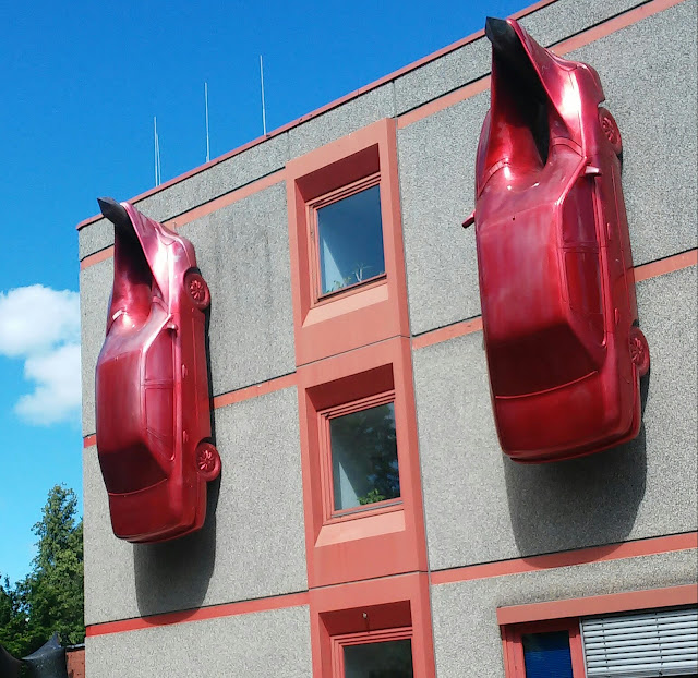 Auto an den Nagel hängen, Nordart, rote Aurtos an der Wand