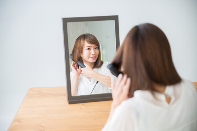 ヘアアイロンをしている女性