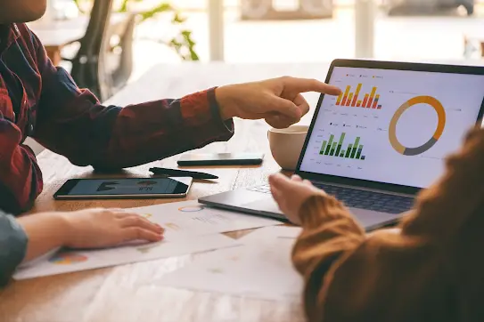 Three teammates  working and discussing business results together in a meeting