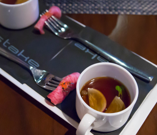 overhead photo of the wagyu sashimi with a mug with broth