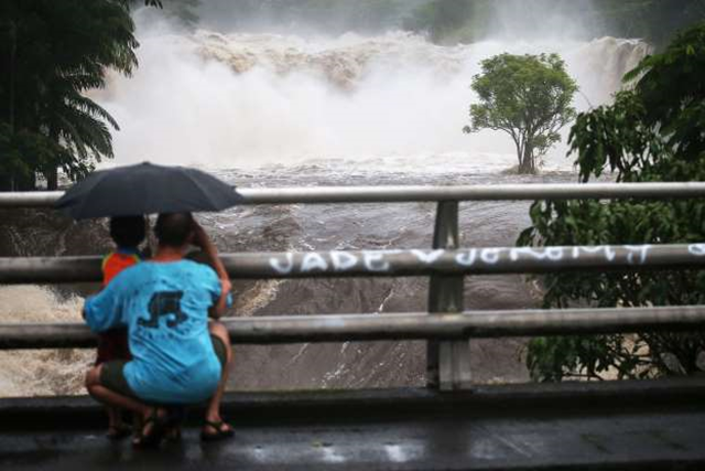 People watch the Wailuku River floods on the Big Island on 23 August 2018 in Hilo, Hawaii. Photo: Mario Tama / Getty Images