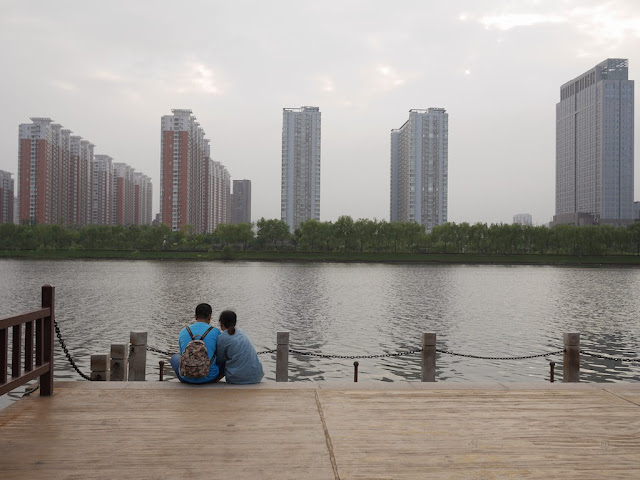 A couple sits looking at the Fen River