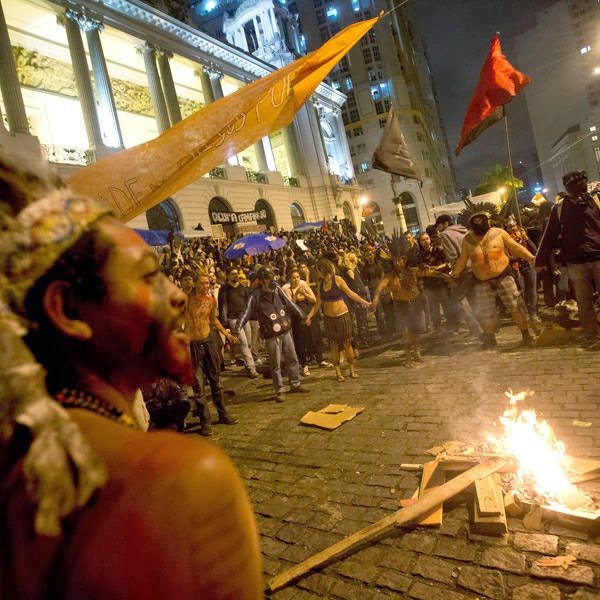 Masked demonstrators throw molotov cocktails at the Palacio Tiradentes, the seat of Rio de Janeiro's Legislative Assembly, following a peaceful teachers protest demanding better working conditions and against police beating, on October 7, 2013 in Rio de Janeiro.